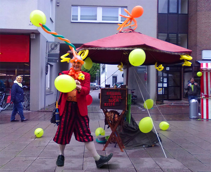 Luftballonkuenstler als kinderunterhalter formt luftballonfiguren auf stadtfest in bremen oder stadtfest in kiel / schleswig-holstein.